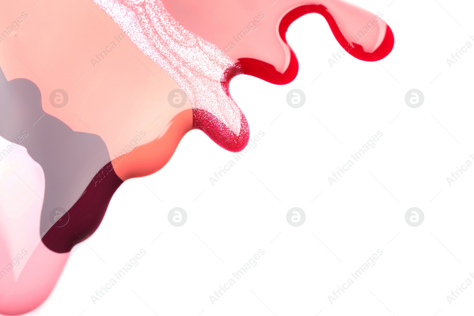 Photo of Colorful nail polishes spilled on white background