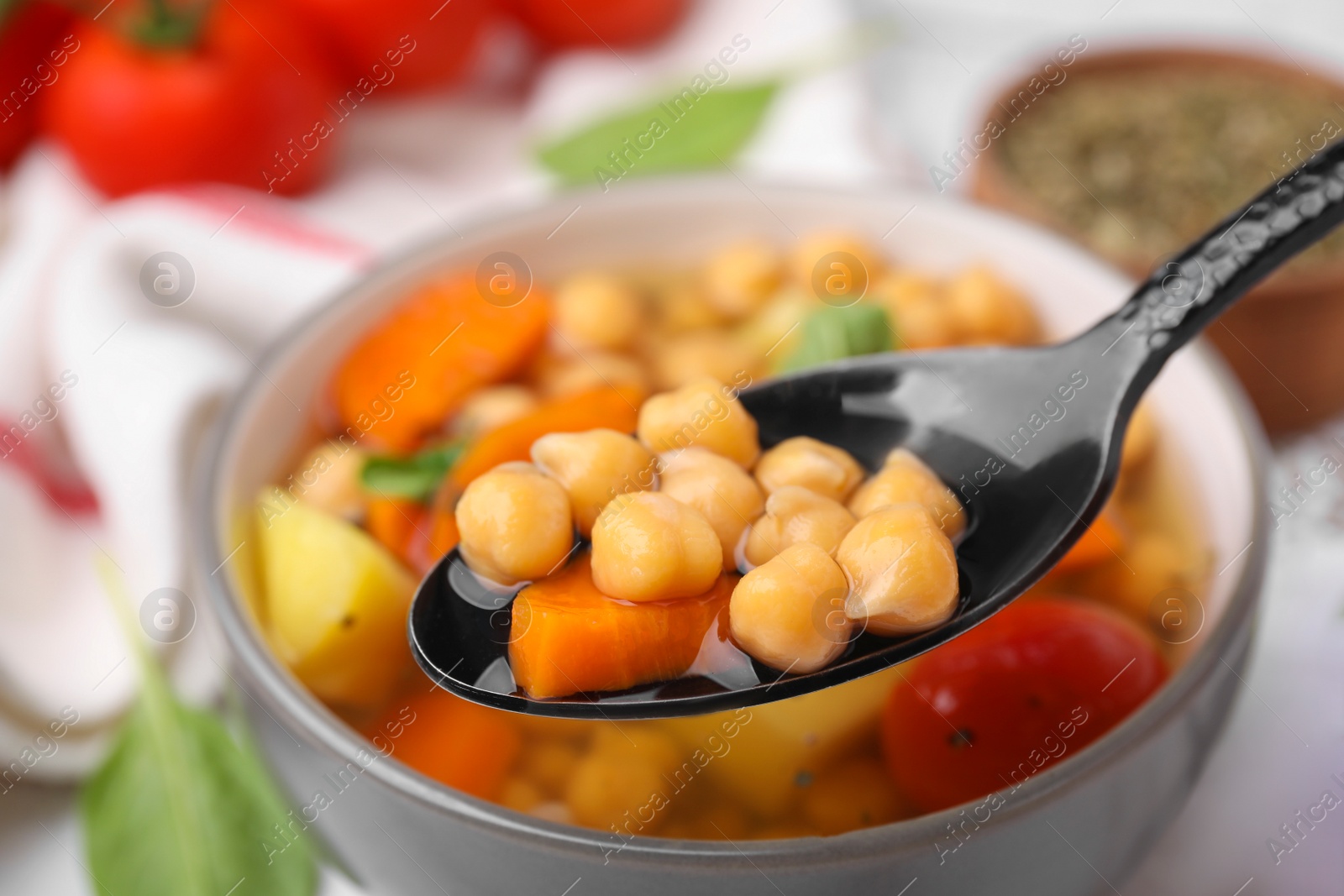 Photo of Eating tasty chickpea soup on table, closeup