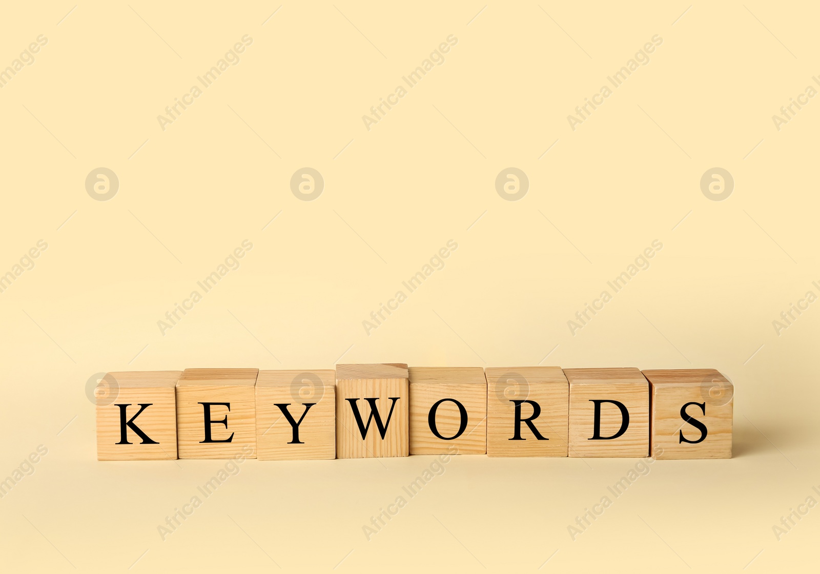 Photo of Cubes with word KEYWORDS on beige background