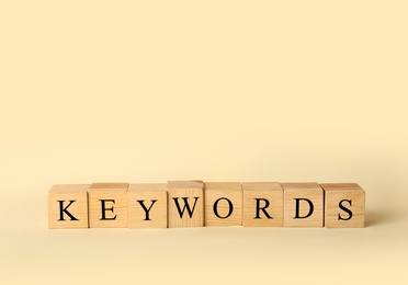 Photo of Cubes with word KEYWORDS on beige background