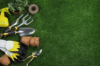 Photo of Flat lay composition with gardening tools and plant on green grass, space for text