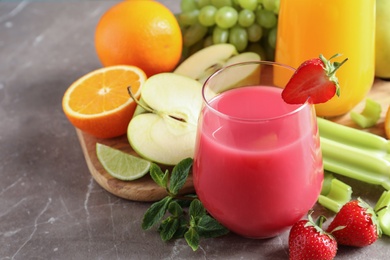 Photo of Glasses with different juices and fresh fruits on table. Space for text