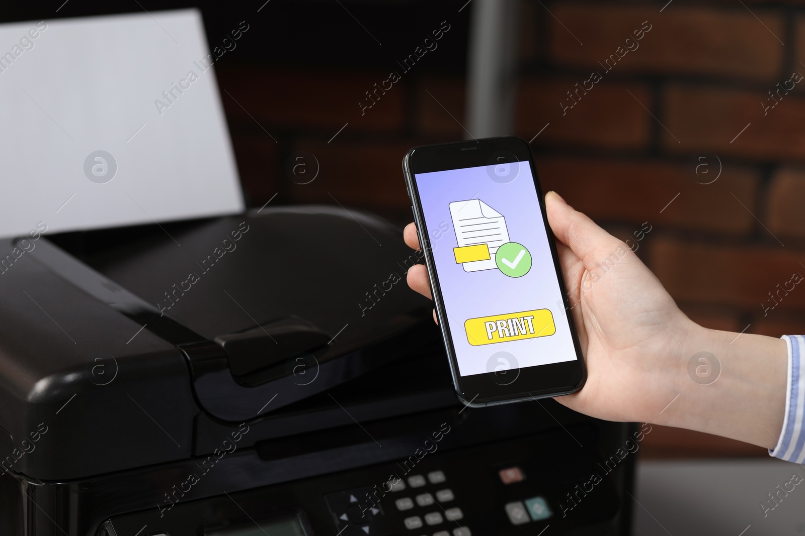 Photo of Man using printer management application on mobile phone indoors, closeup. Image on device screen.