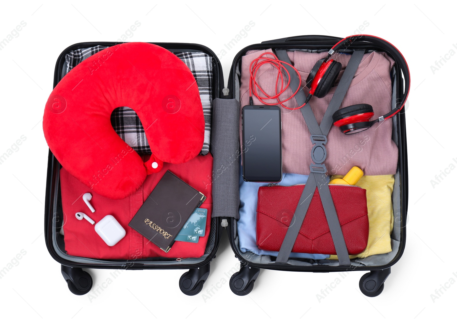 Photo of Soft travel pillow, hat, passports and other items in open suitcase isolated on white, top view