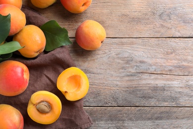 Delicious fresh ripe apricots on wooden table, flat lay. Space for text