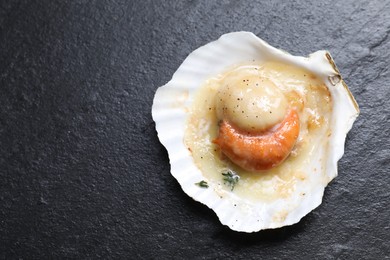 Photo of Fried scallop in shell on black table, top view. Space for text