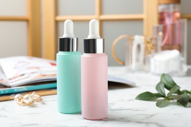 Bottles of cosmetic products on white marble table