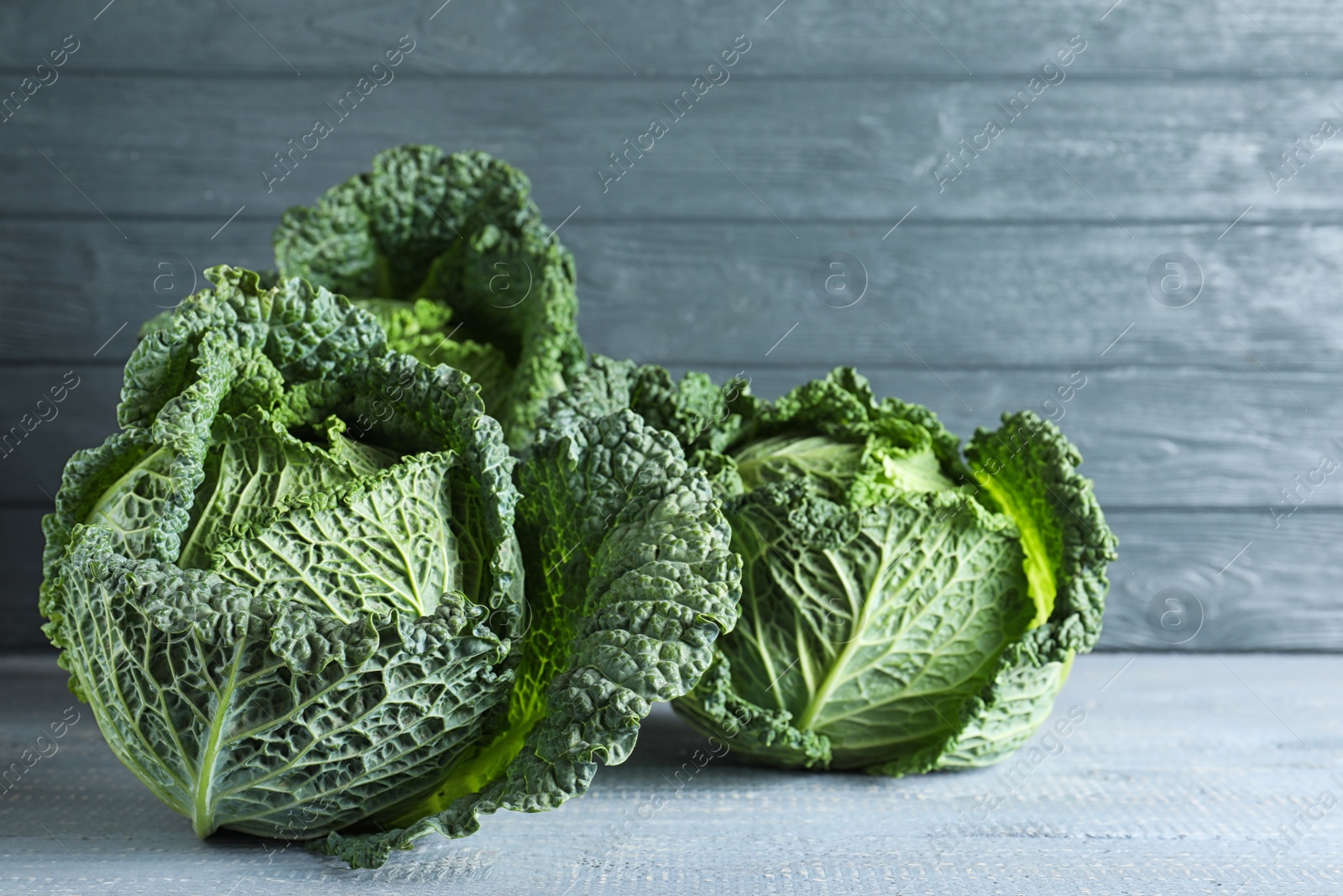 Photo of Fresh green savoy cabbages on wooden table