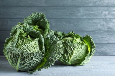 Photo of Fresh green savoy cabbages on wooden table