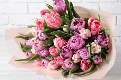 Bouquet of beautiful tulips on white wooden table, closeup