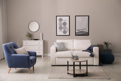Photo of Stylish living room interior with white sofa, armchair and small coffee table