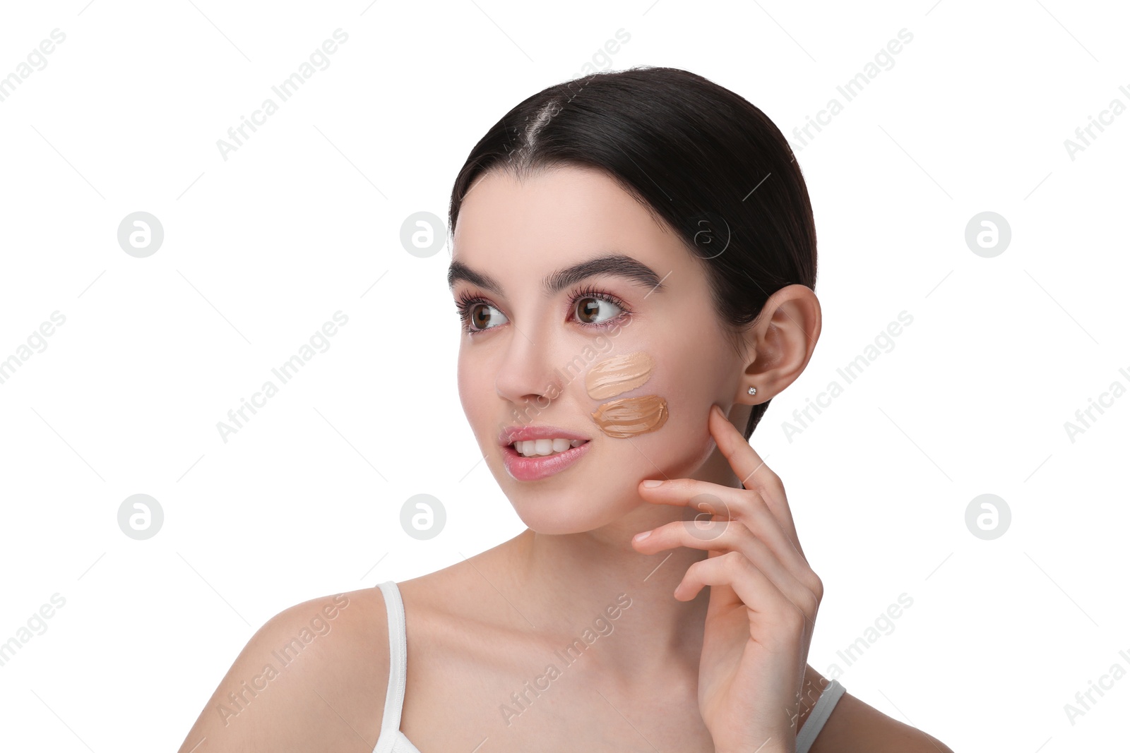 Photo of Teenage girl with swatches of foundation on face against white background