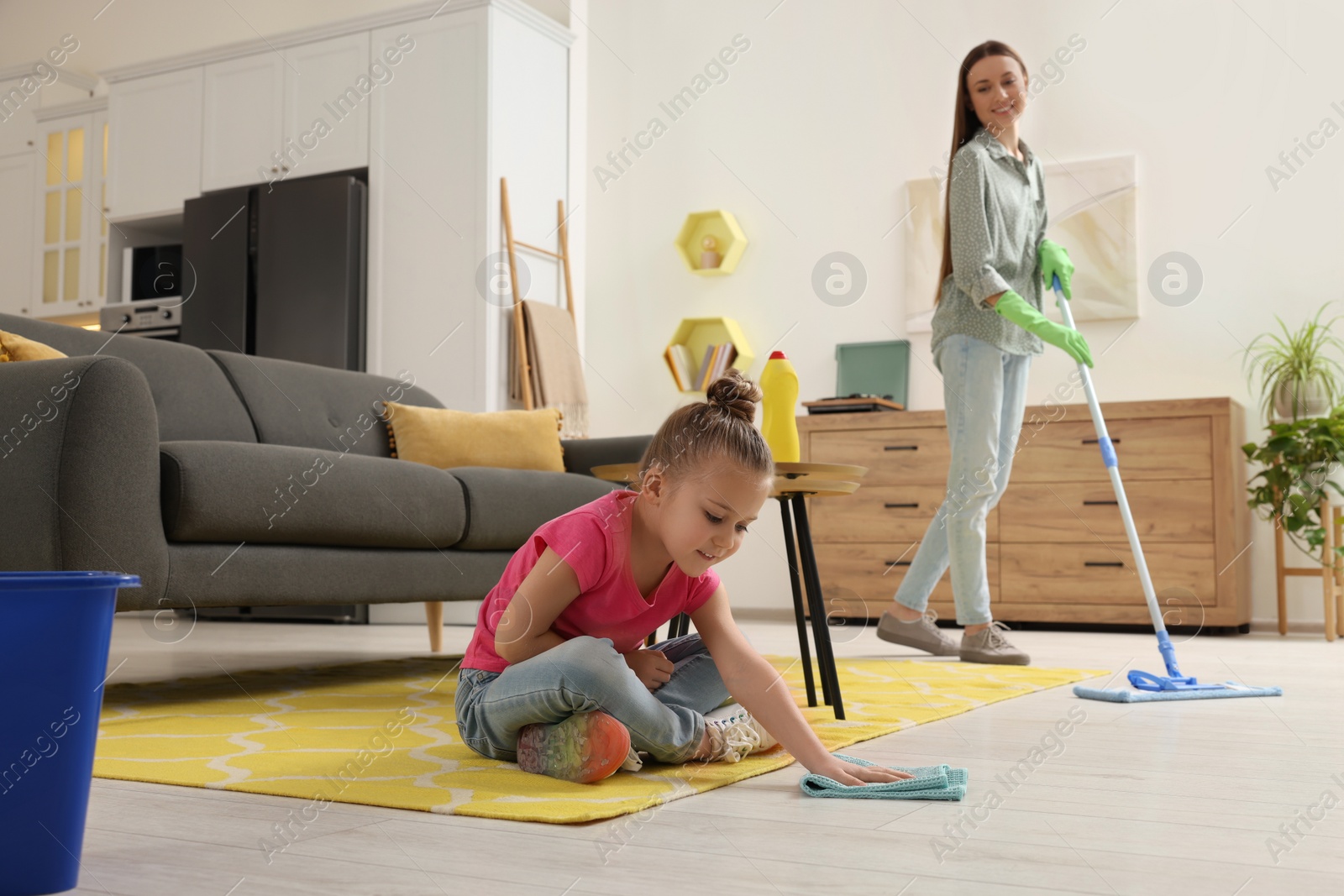 Photo of Spring cleaning. Mother and daughter tidying up living room together