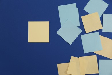 Colorful sticky notes on blue background, flat lay