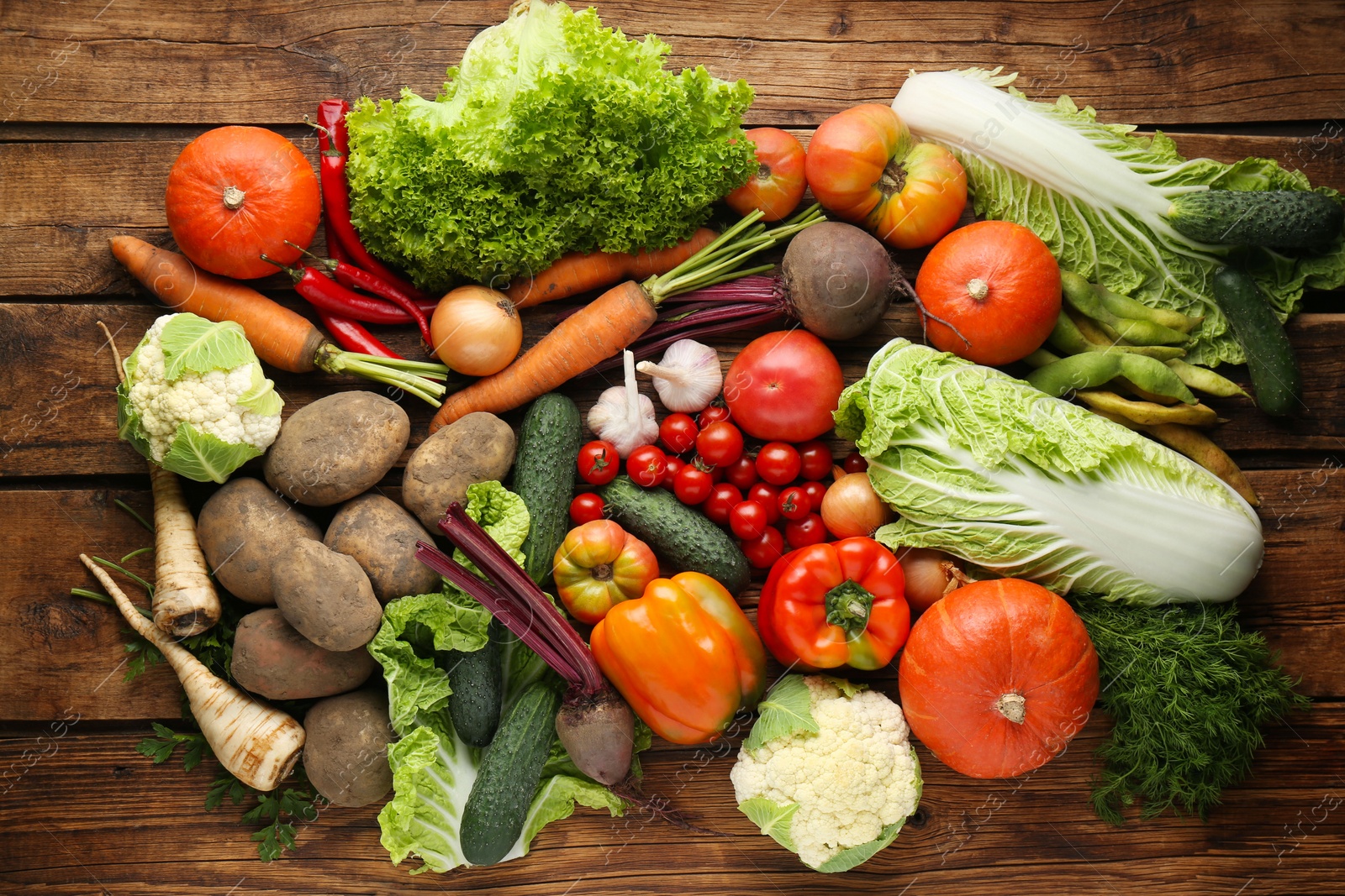 Photo of Different fresh ripe vegetables on wooden table, flat lay. Farmer produce