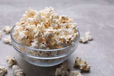 Bowl of tasty popcorn on grey table, closeup. Space for text