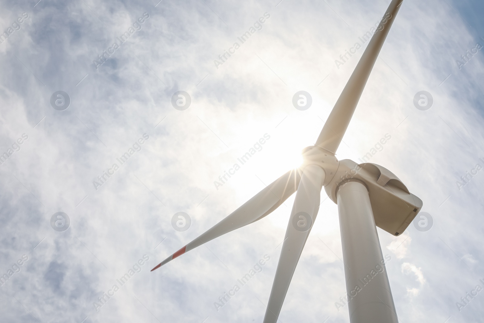 Photo of Modern wind turbine against cloudy sky, closeup. Alternative energy source