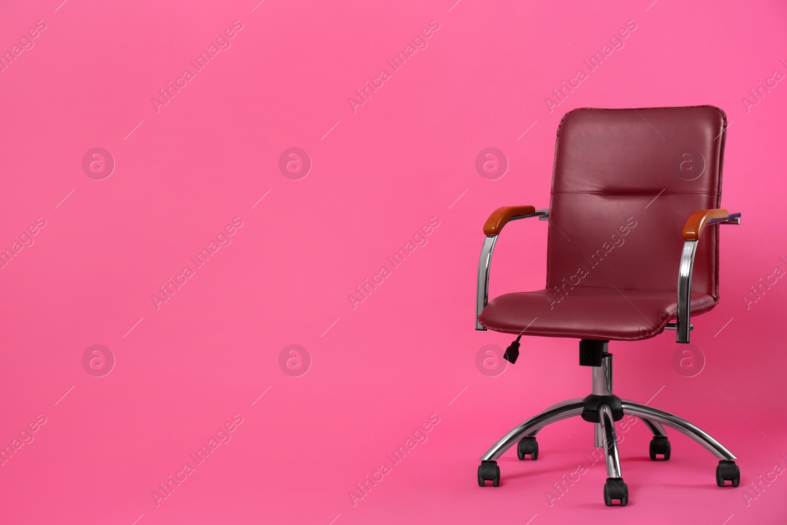 Photo of Comfortable office chair on pink background, space for text