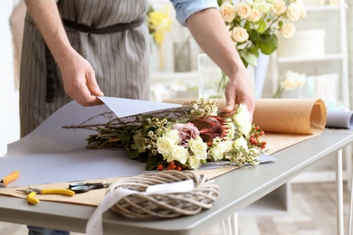 Male florist creating bouquet at workplace