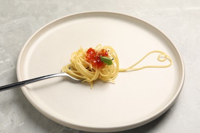 Photo of Heart made with spaghetti and fork on grey table