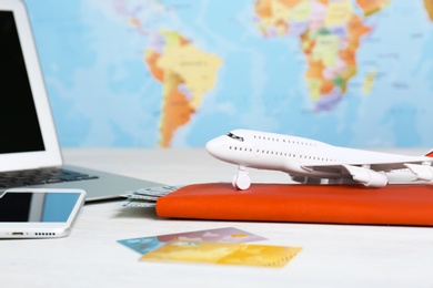 Photo of Composition with toy plane and laptop on table against map. Travel agency