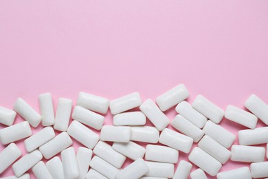 Tasty white chewing gums on pale pink background, flat lay. Space for text