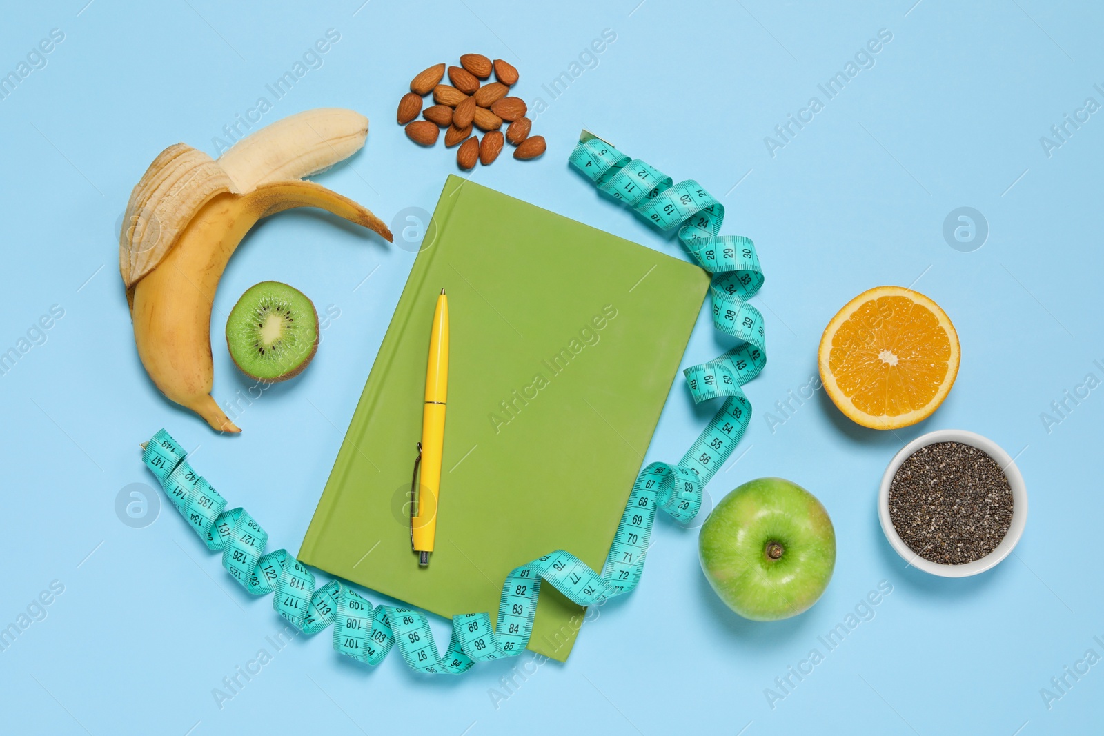 Photo of Weight loss concept. Flat lay composition with notebook, measuring tape and different products on light blue background