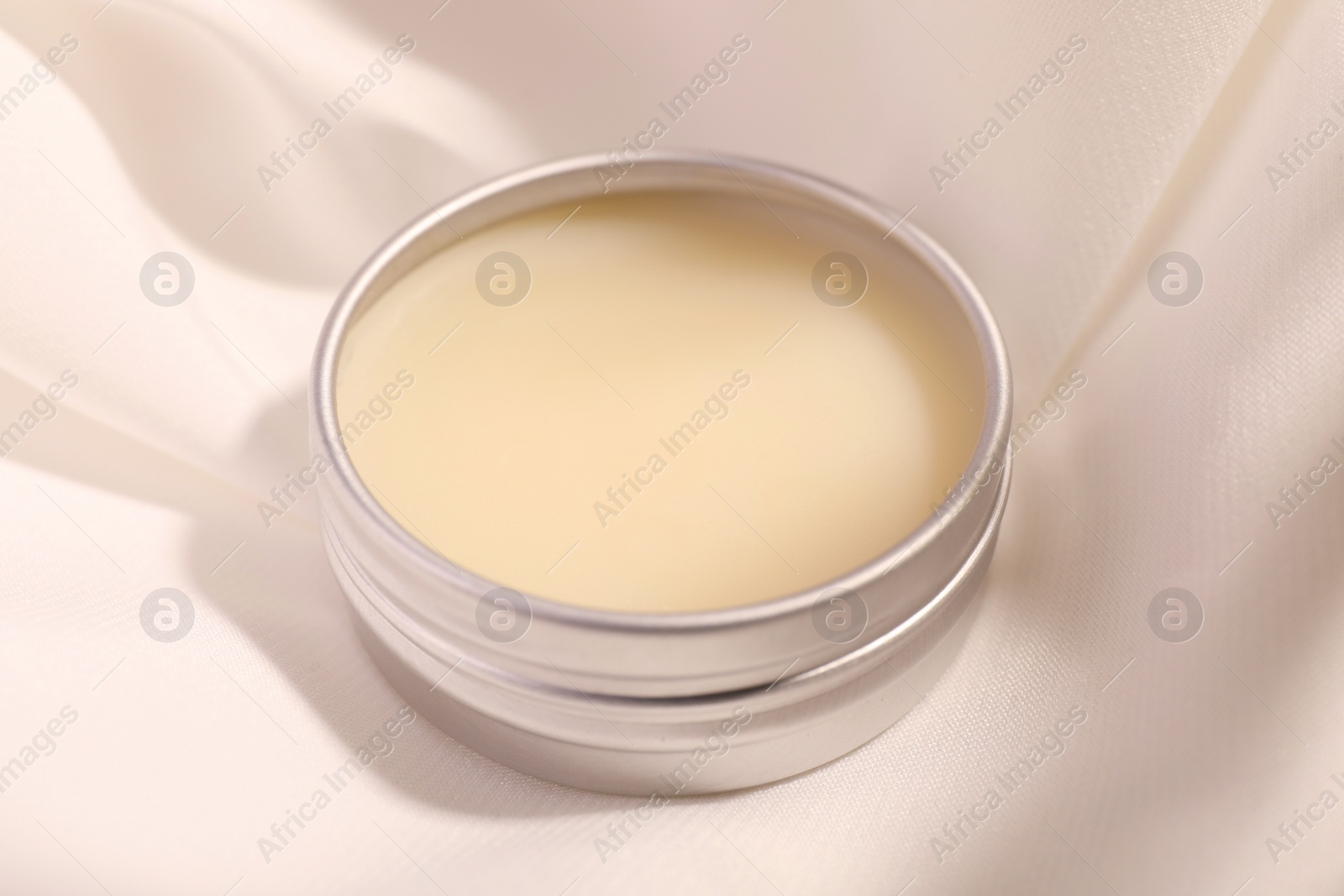 Photo of Lip balm on white fabric, closeup view