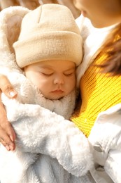 Mother with her sleeping baby son outdoors, closeup