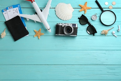 Photo of Flat lay composition with toy airplane and travel items on light blue wooden background. Space for text