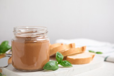 Delicious meat pate, fresh bread and basil on white table. Space for text