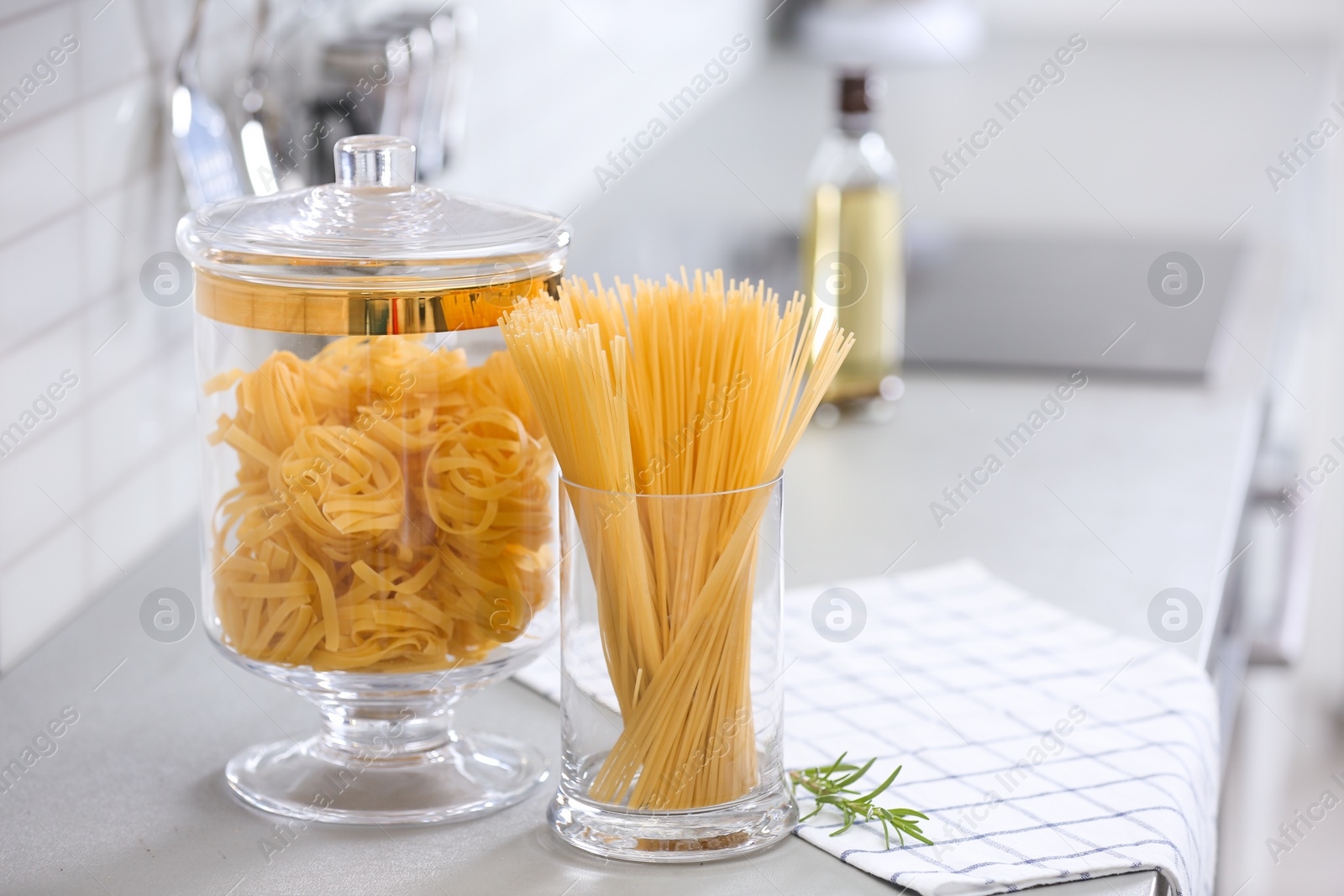 Photo of Raw pasta on light grey table in modern kitchen