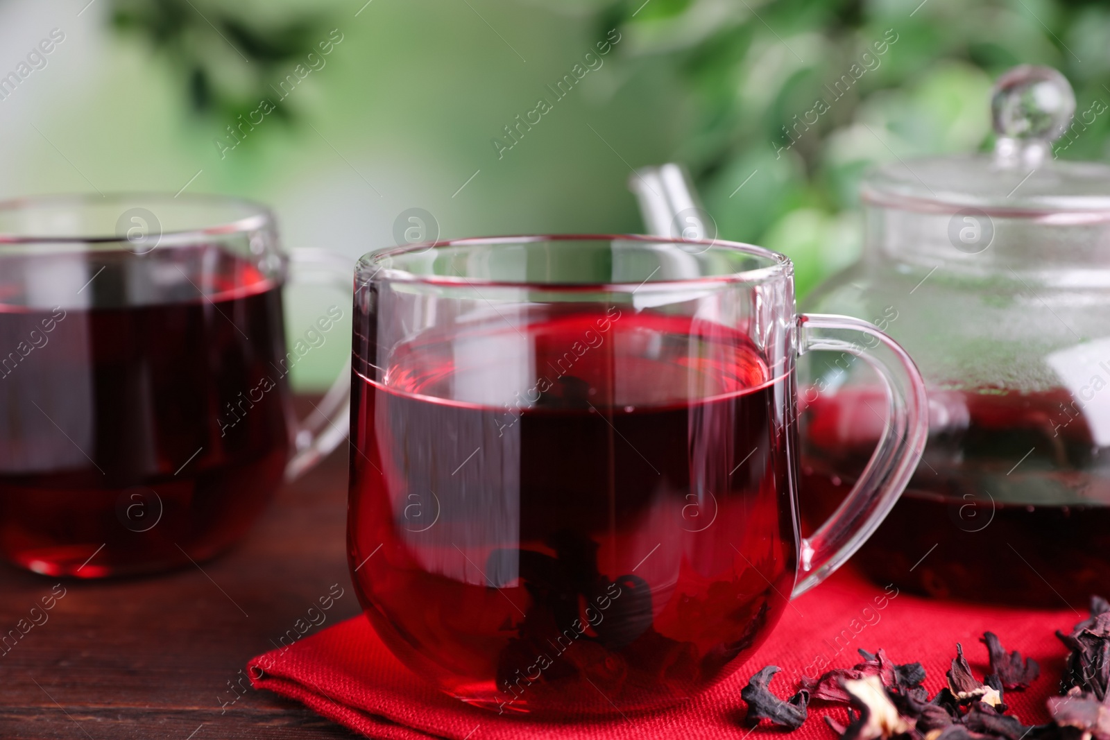 Photo of Freshly brewed hibiscus tea on wooden table, closeup