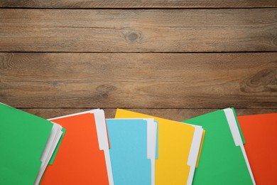 Photo of Different files with documents on wooden table, flat lay. Space for text