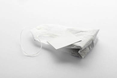 Photo of Unused tea bag with tag on white background