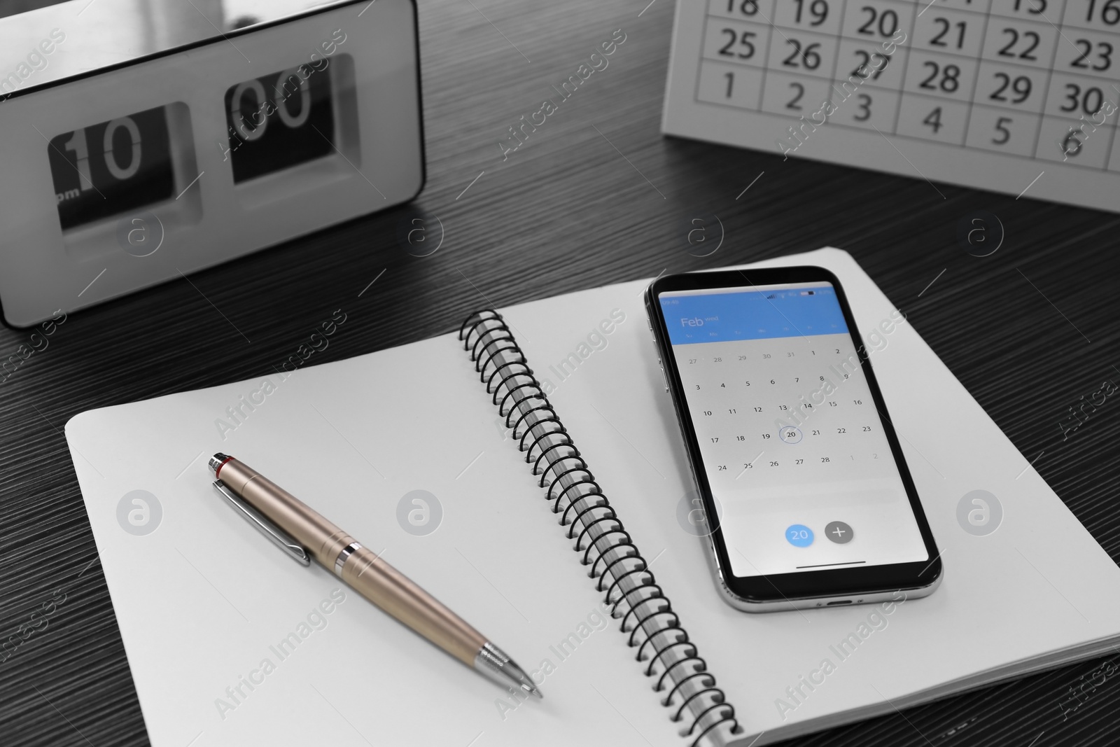 Photo of Modern smartphone with calendar on screen in office