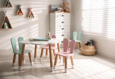 Small table and chairs with bunny ears in children's room interior