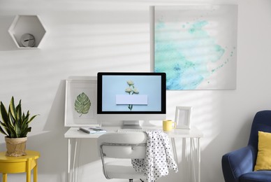 Photo of Comfortable office chair near desk with modern computer indoors