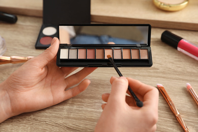 Photo of Woman applying makeup at dressing table, closeup