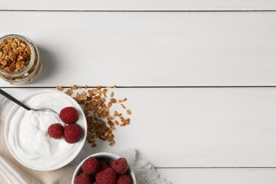 Yogurt served with granola and raspberries on white wooden table, flat lay. Space for text