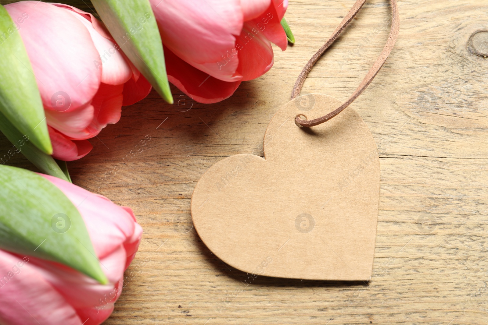 Photo of Happy Mother's Day. Beautiful tulips with blank heart shaped card on wooden table, closeup