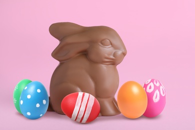 Image of Chocolate bunny and painted Easter eggs on pink  background