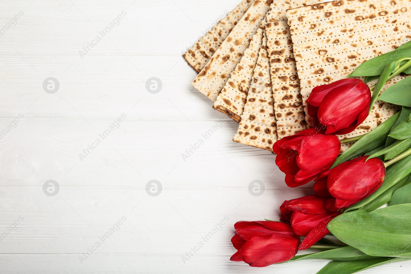 Photo of Flat lay composition with traditional Pesach (Passover Seder) matzo on white wooden table. Space for text