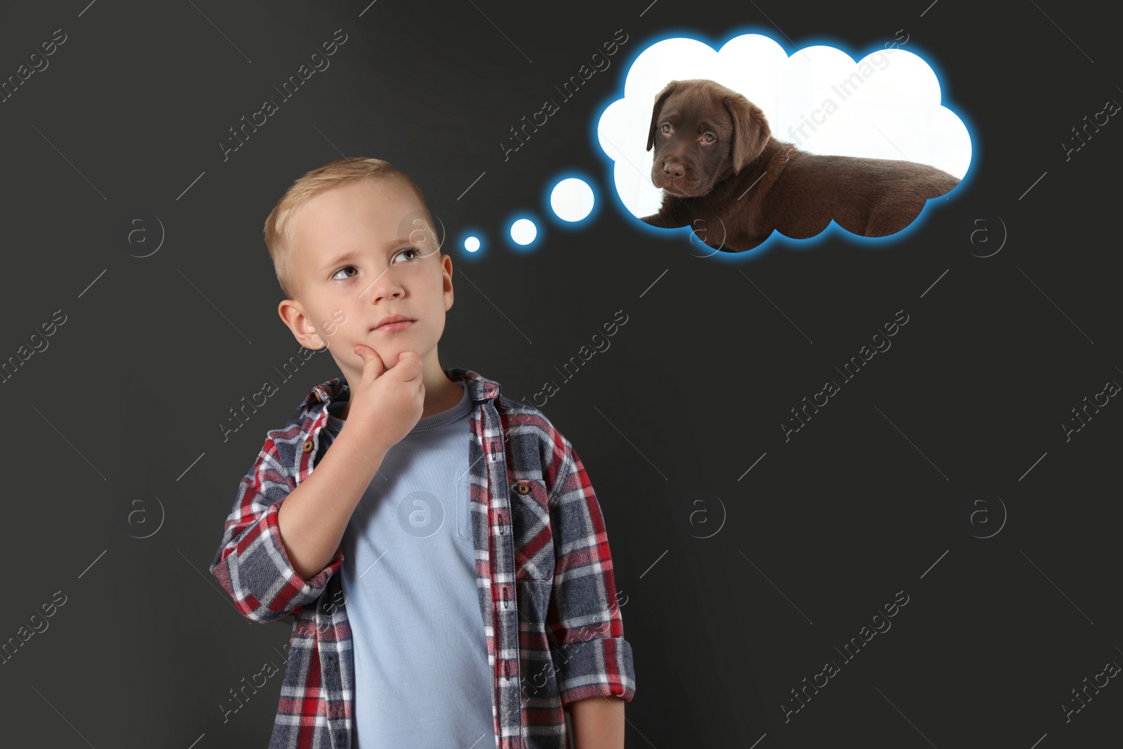 Image of Little boy dreaming about cute puppy, dark background