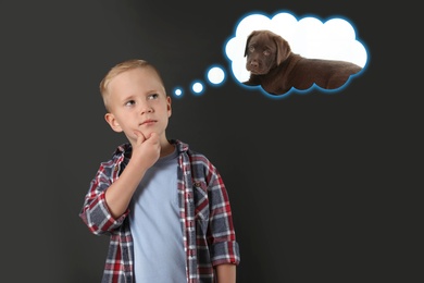 Image of Little boy dreaming about cute puppy, dark background