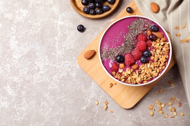 Delicious acai with granola and berries served on marble table, flat lay. Space for text