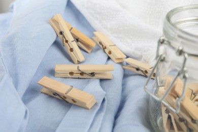 Photo of Many wooden clothespins on light blue fabric