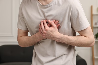 Photo of Man suffering from heart hurt at home, closeup