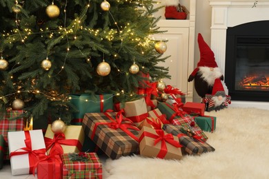 Many gift boxes under beautiful Christmas tree in room