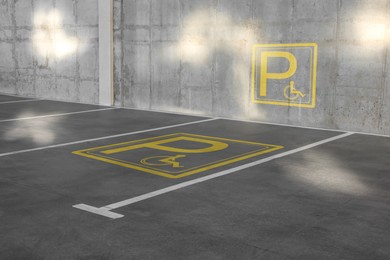 Car parking lot with white marking lines and wheelchair symbol outdoors 